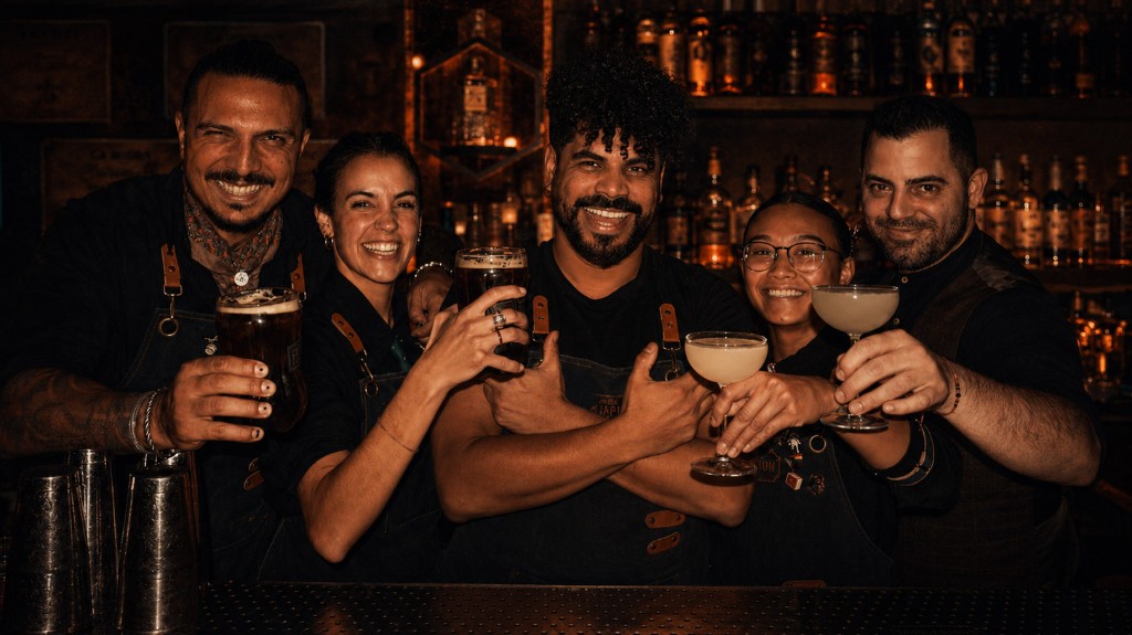 The Especiarium Bar team raising a toast behind the bar